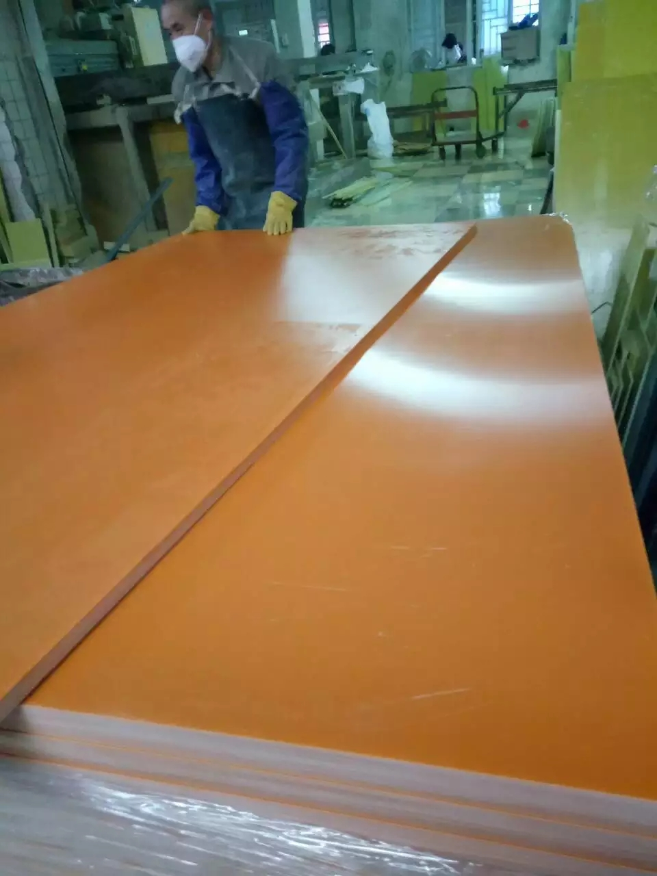 High-quality orange phenolic paper laminate sheets stacked in factory storage